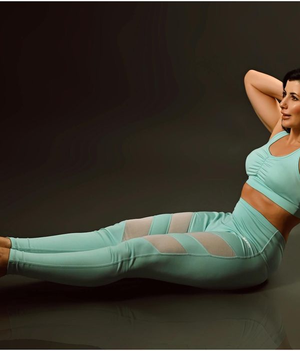 Woman in a graceful yoga pose with cyan light accents.